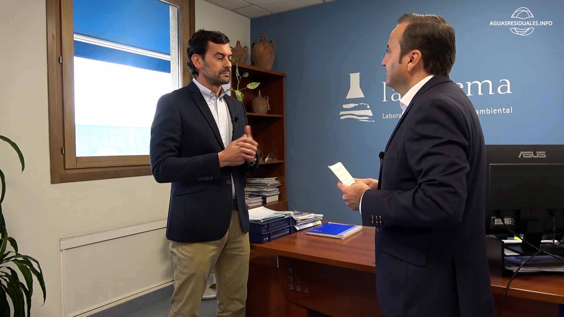 Dos hombres conversan en oficina corporativa